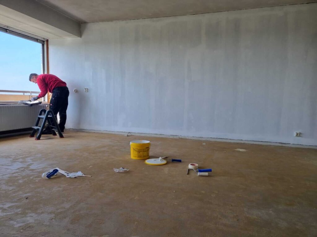 De muren en plafonds van de woning worden geschilderd